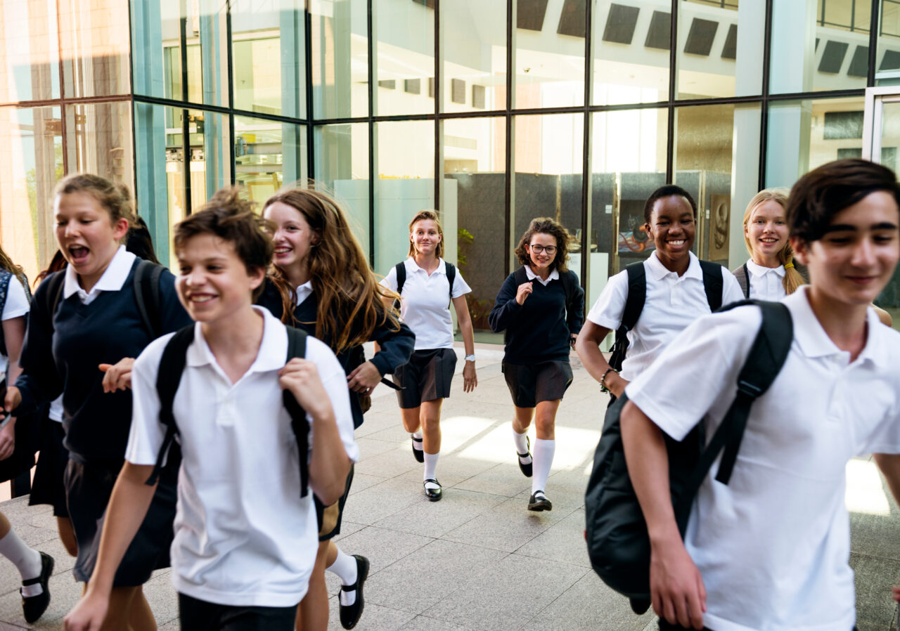 21477877e3589fa1d8b3862aa07af983797530dc Students walking through a school courtyard between classes